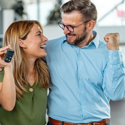 happy couple with keys to new car