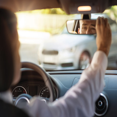 guy driving looking in his rearview mirror
